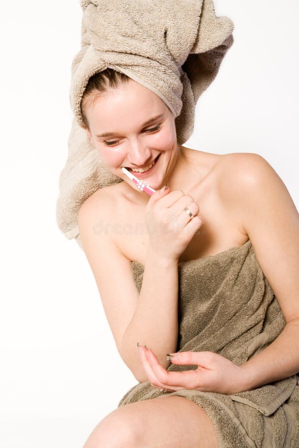 Woman is brushing her teeth and smiling