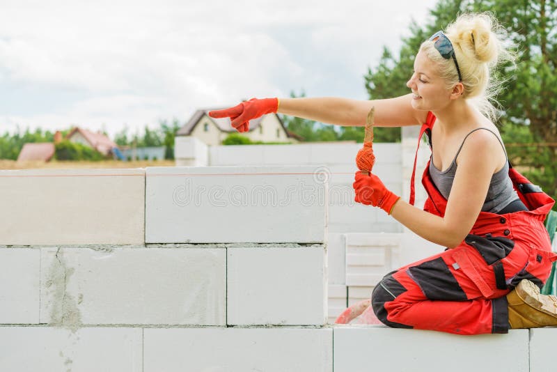 Woman using string as level in wall construction royalty free stock photos
