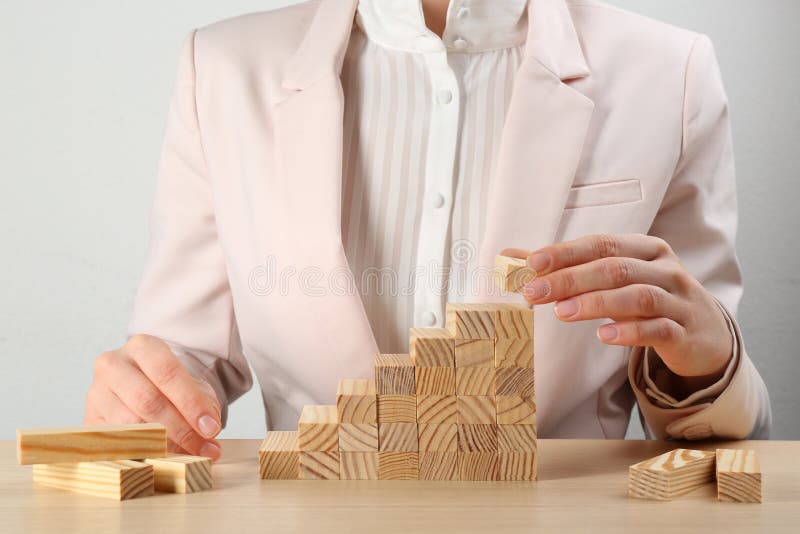 Woman building stairs at table, closeup. Career promotion concept