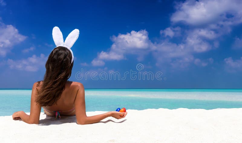 Femeie cu urechi de iepure și ouă colorate de paști stock photography