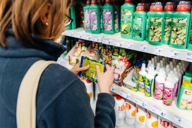Woman buying plant fertilizer in DIY store gardening store stock images Woman buying plant fertilizer in DIY store gardening store stock images