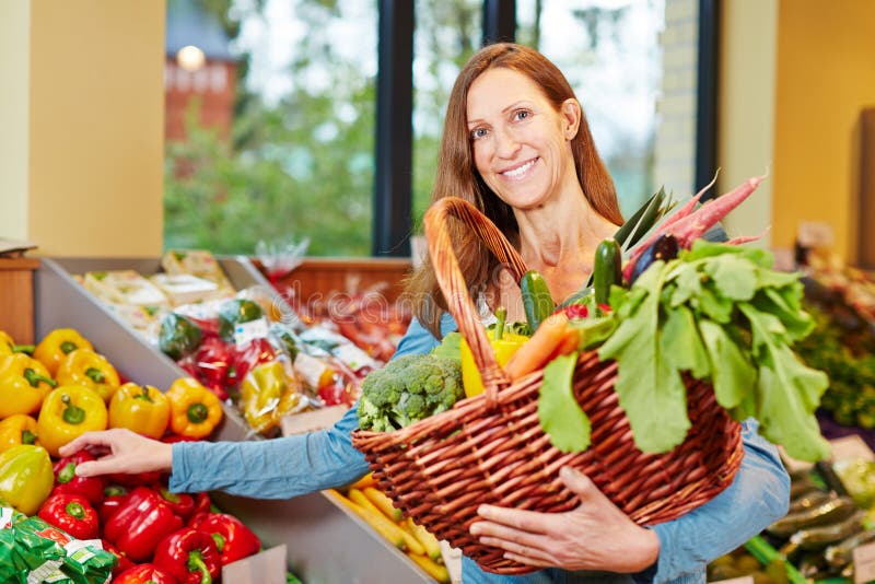 Woman buying vegetables in organic food store stock images Woman buying vegetables in organic food store stock images