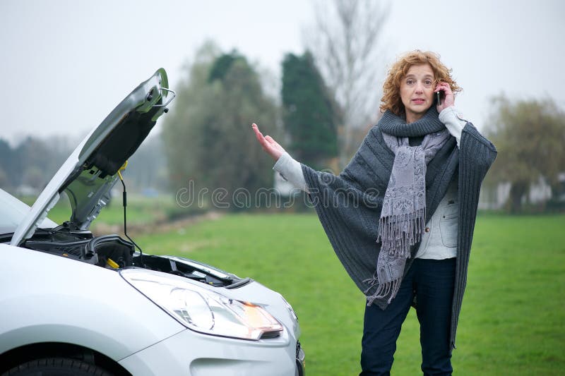 Donna sul telefono cellulare che ha bisogno di aiuto perché la sua auto si è rotta.