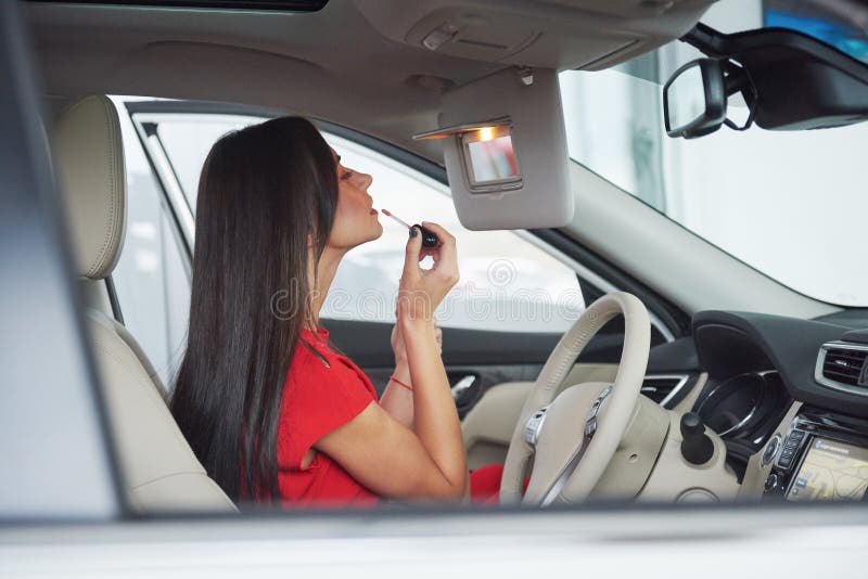 Woman in car indoor keeps wheel turning around smiling looking at passengers in back seat idea taxi driver against royalty free stock images Woman in car indoor keeps wheel turning around smiling looking at passengers in back seat idea taxi driver against royalty free stock images