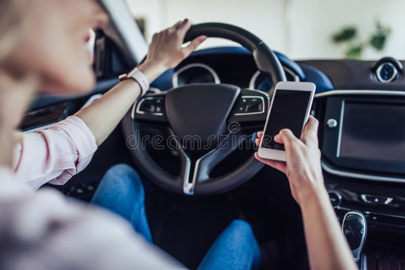 Woman in the car using smartphone stock photography