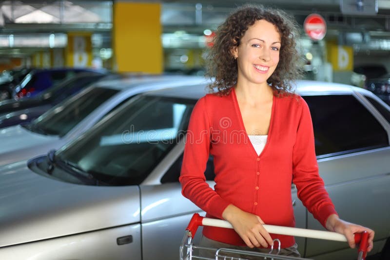 Woman with cart standing in underground car park stock photography Woman with cart standing in underground car park stock photography