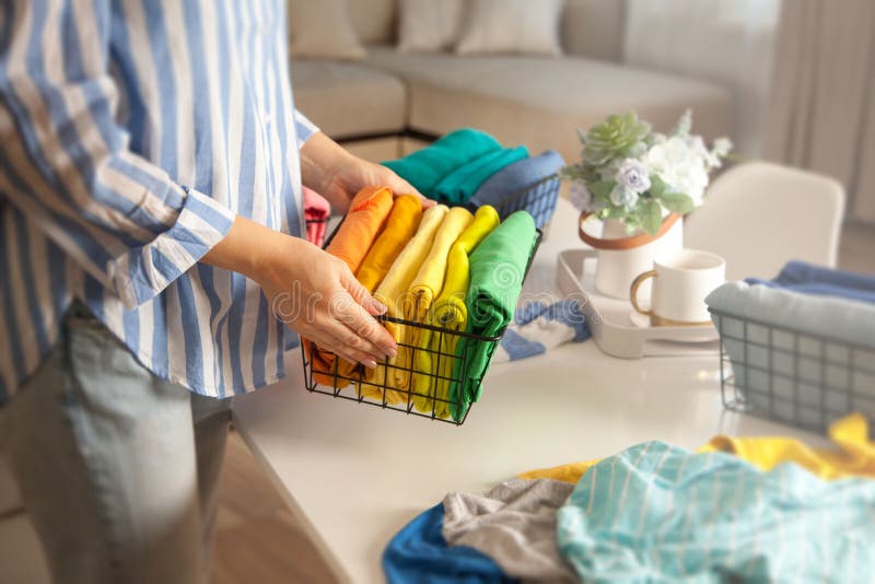 Woman in casual clothes lays clothes in metal mesh