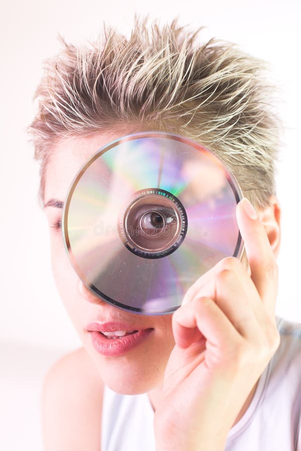 Blond short hair woman woman with white Tshirt looking through a CD hole. Girl peeing stock images, royalty-free photos and pictures
