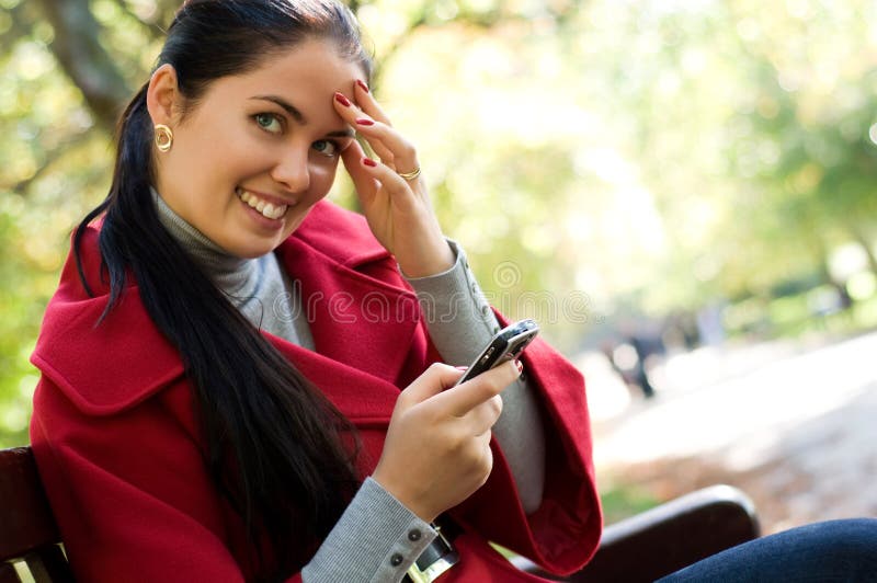 Woman with a cell phone, sitting in a park