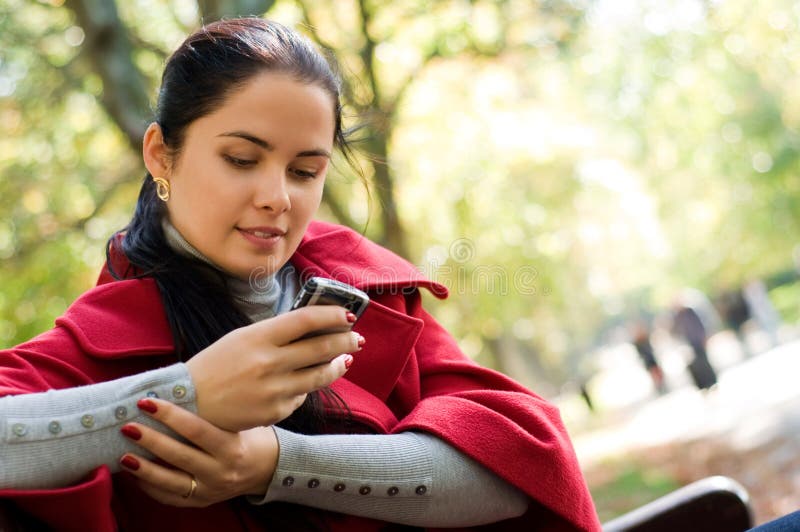 Woman with a cell phone, sitting in a park