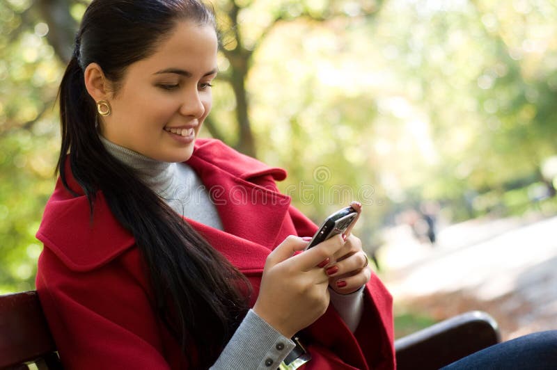 Woman with a cell phone, sitting in a park