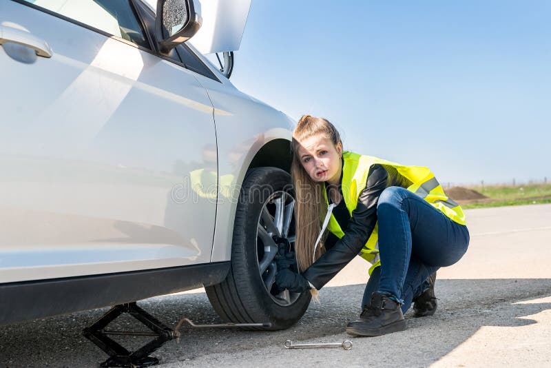 Had a flat tyre. Женщина меняет колесо. Женщина меняет колесо фото. Бизнес леди меняет колесо. Женщина меняет колеса в машине приколы картинки.