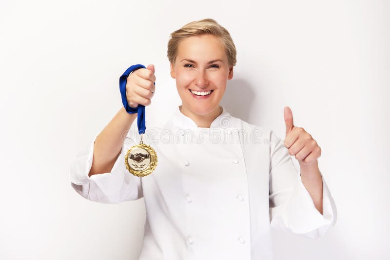 Woman in chef outfit with thumb up and first prize medal smiling