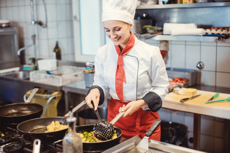 Woman Chef with Pans and Pots Preparing Food in the Restaurant Kitchen