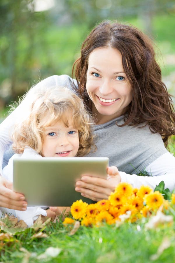 Woman and child using tablet PC outdoors stock photography