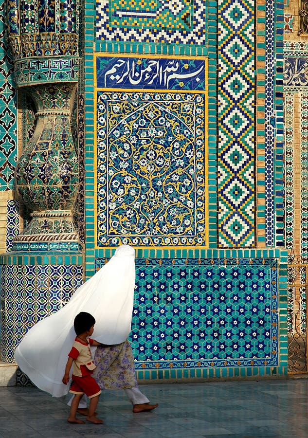 A woman and child walk past the Blue Mosque in Mazar i Sharif, Afghanistan