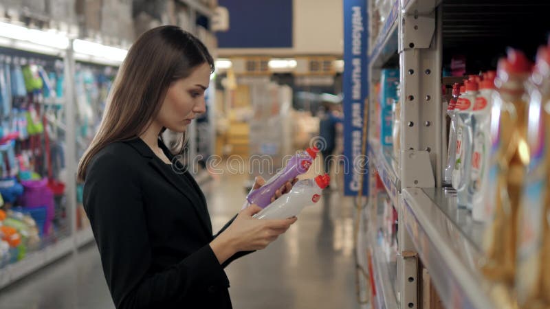 Woman choosing laundry detergent in grocery store. Businesswoman in supermarket stock photos Woman choosing laundry detergent in grocery store. Businesswoman in supermarket stock photos