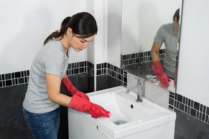 Woman cleaning bathroom sink with brush stock photos Woman cleaning bathroom sink with brush stock photos