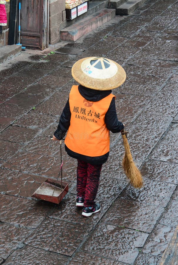 A woman cleaning at Fenghuang Ancient Town in Hunan, China