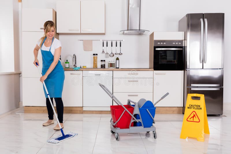 Woman Cleaning Kitchen Floor With Mop royalty free stock photo