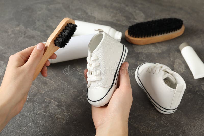 Washing Shoe with Foam Cleaner. White Leather Footwear and