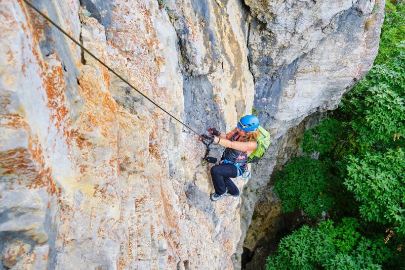 Woman climber on a via ferrata route called Dragons Amphitheater Amfiteatrul Zmeilor in Baia de Fier, Gorj county, Romania