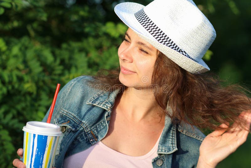 Woman with cocktail relaxes in park stock photo Woman with cocktail relaxes in park stock photo