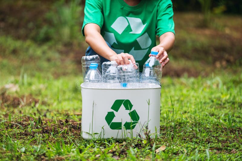 A woman collecting and putting plastic bottles into a recycle bin