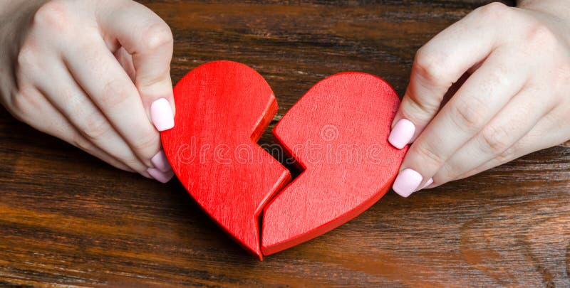 A woman collects a broken heart in his hands. Concept of love and relationships. Family psychotherapist services. Reconciliation. royalty free stock photos A woman collects a broken heart in his hands. Concept of love and relationships. Family psychotherapist services. Reconciliation. royalty free stock photos