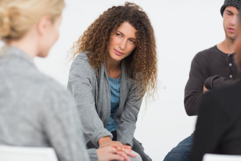 Woman comforting another in rehab group at a therapy session. Woman comforting another in rehab group at a therapy session