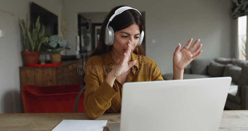Woman conducting virtual meeting sits at table with laptop stock footage