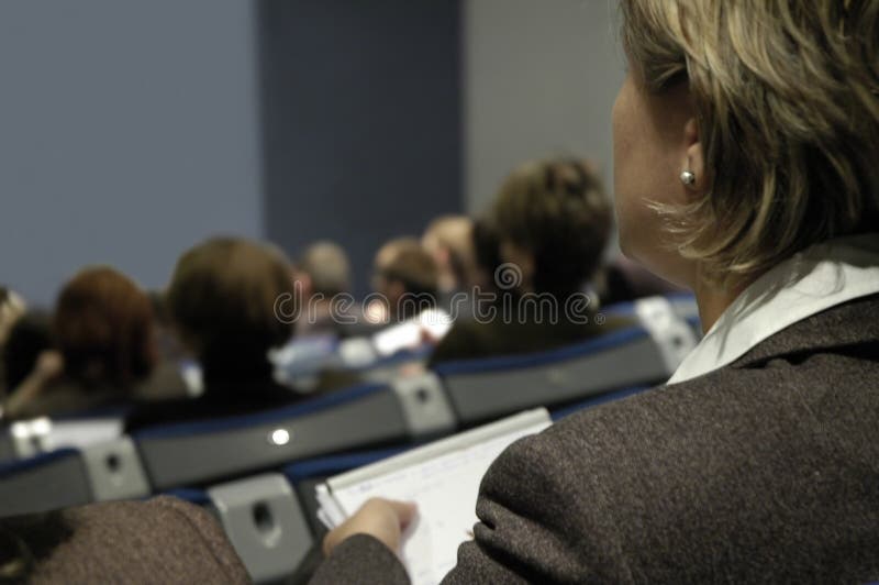 Žena počas konferencia, držanie poznámkový blok.