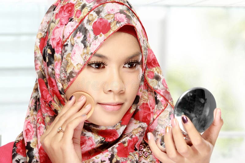 Woman with cotton pad applying face powder