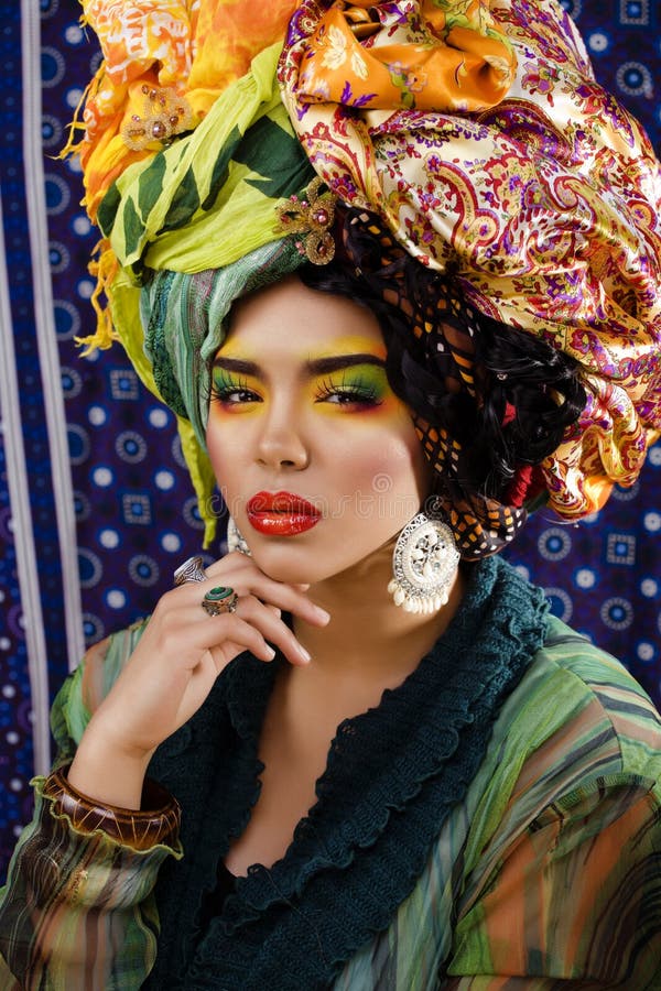 Woman with creative make up, many shawls on head like cubian woman