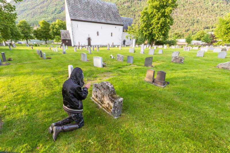 Triste una mujer llanto sobre el cementerio a ora.