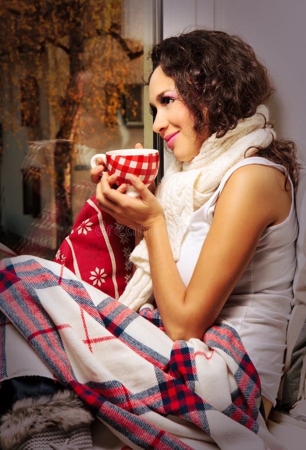 Woman with cup of coffee or tea at home