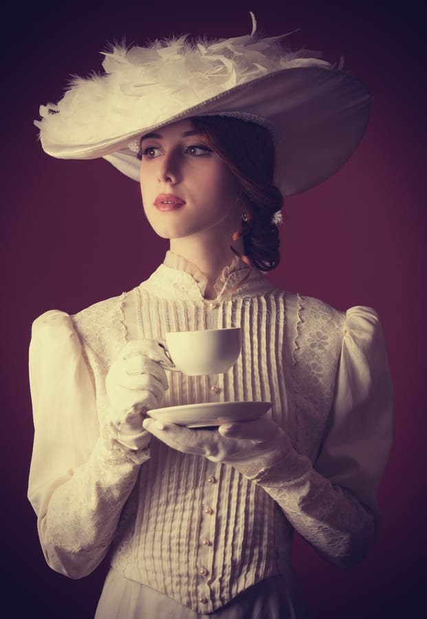 Bella donna rossa con la tazza di tè.