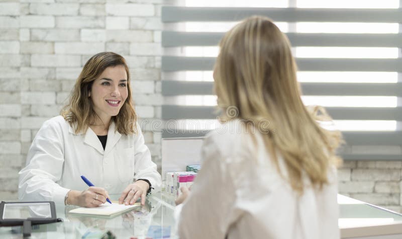 Woman customer in pharmacy with doctor woman ready for prescript stock photography Woman customer in pharmacy with doctor woman ready for prescript stock photography