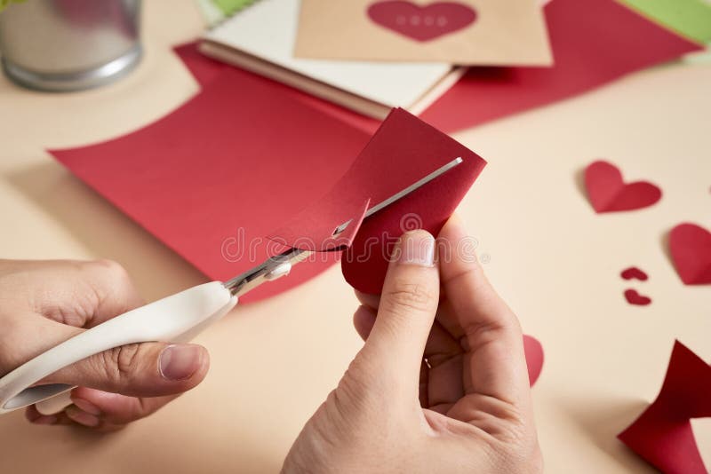 woman cuts out red felt hearts, homemade crafts for Valentine`s day, hand made creativity. royalty free stock photo woman cuts out red felt hearts, homemade crafts for Valentine`s day, hand made creativity. royalty free stock photo