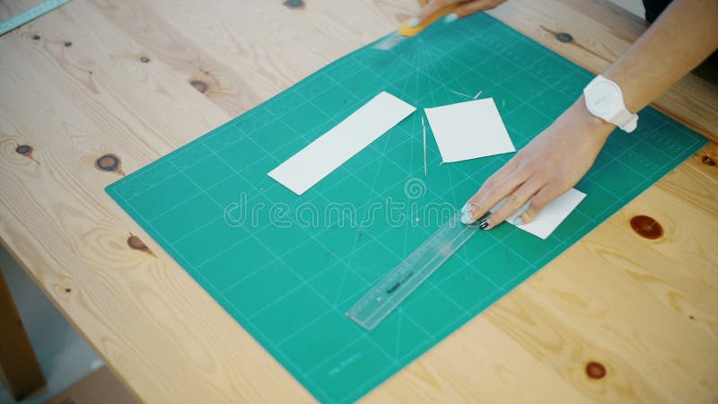 Woman cuts the paper on the table