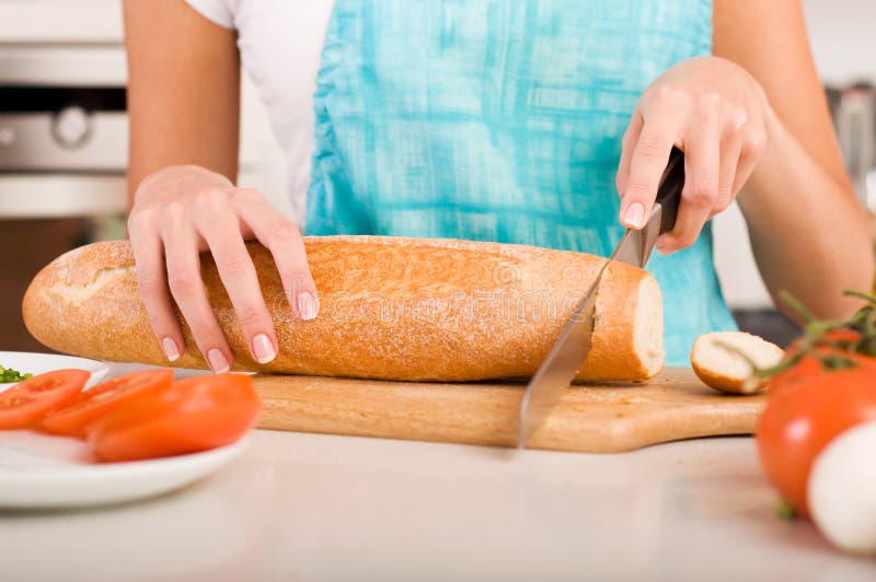 Woman cutting bread on the kitchen