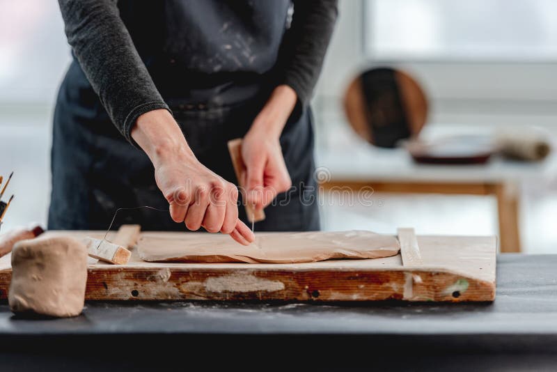 Woman Cutting Clay Using Wire at Stock Photo Image of