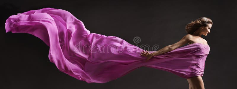 Woman dancing. Modern Ballet Dancer with long Pink Fabric Banner flying on Wind in Air. Copy Space over Black Background. Woman dancing. Modern Ballet Dancer with long Pink Fabric Banner flying on Wind in Air. Copy Space over Black Background