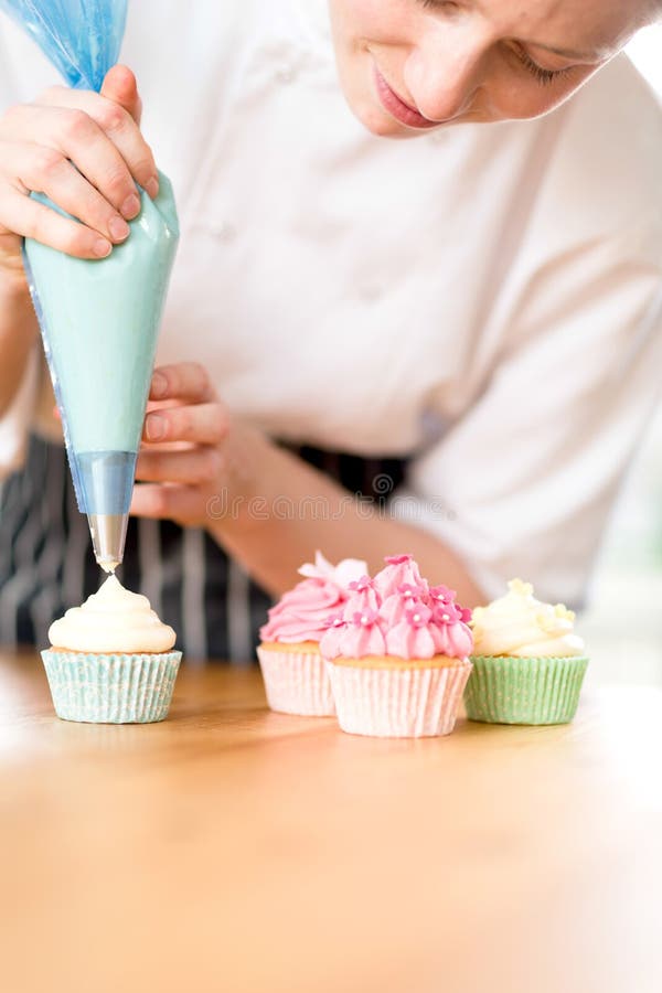 Woman decorating homemade cupcakes with cream royalty free stock images Woman decorating homemade cupcakes with cream royalty free stock images