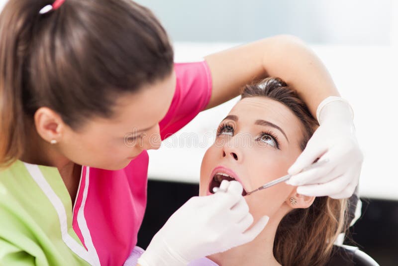 Woman dentist checking her patient royalty free stock photo