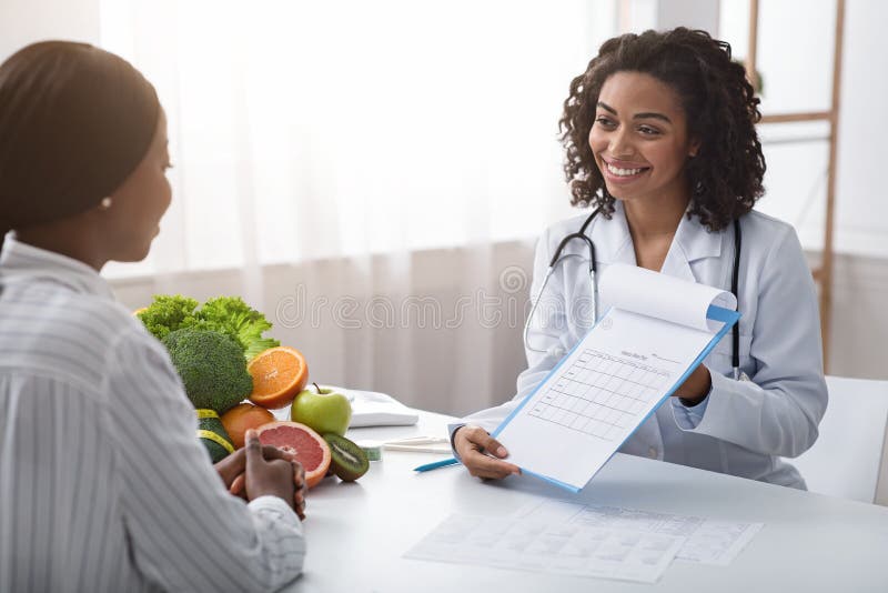 Woman dietician showing female patient medical chart royalty free stock images Woman dietician showing female patient medical chart royalty free stock images