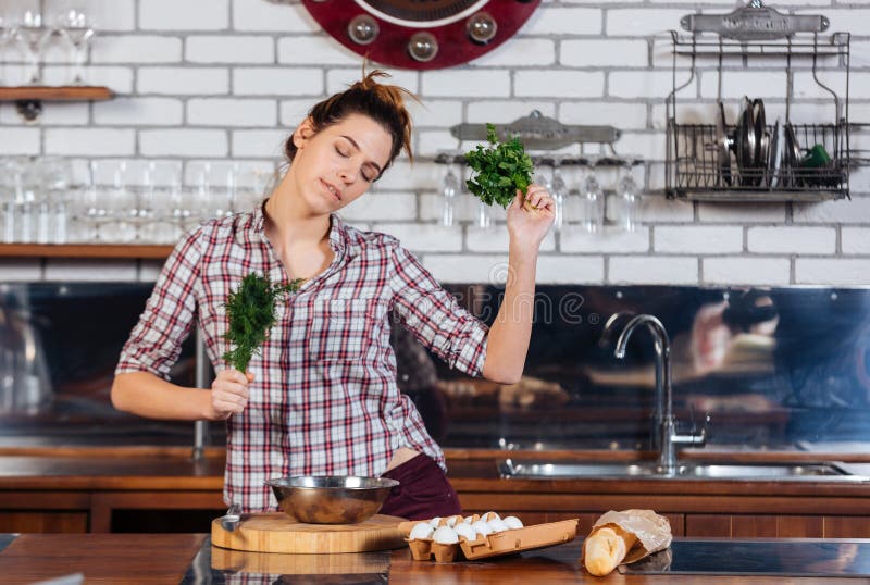 Woman with dill and parsley dacing on the kithen