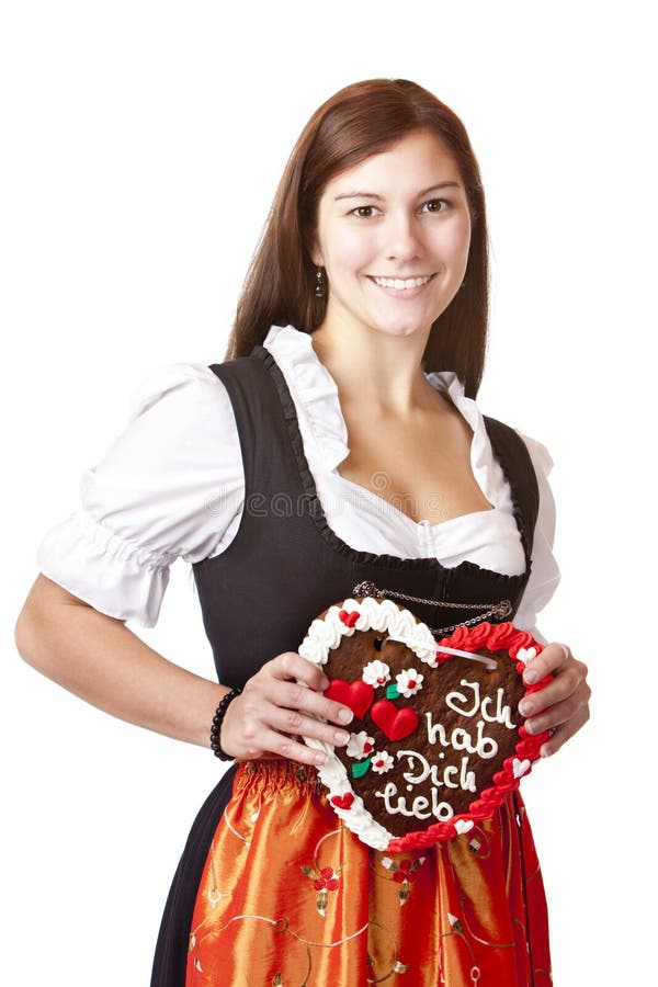 Woman in Dirndl holds gingerbread heart