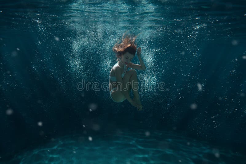 Woman dives underwater. stock photo