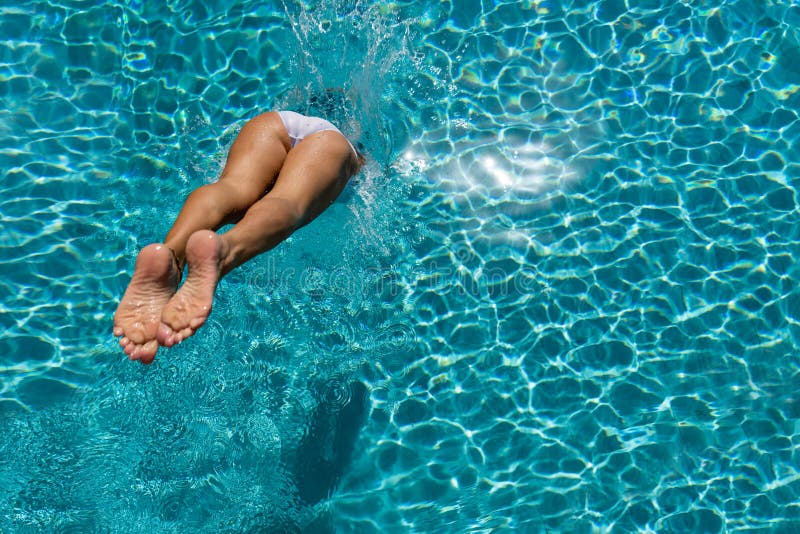 Woman diving  at luxury five stars  spa resort in the swimming pool in Greece